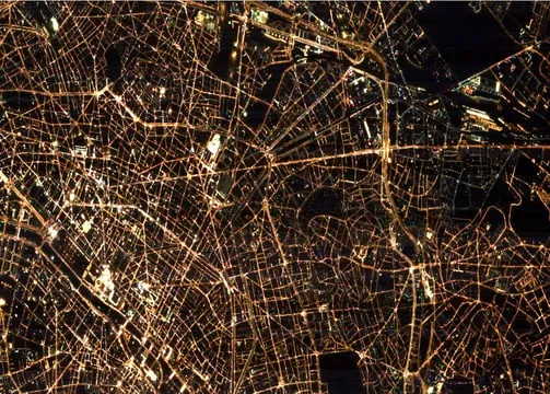 City street grid glowing at night, photographed from orbit